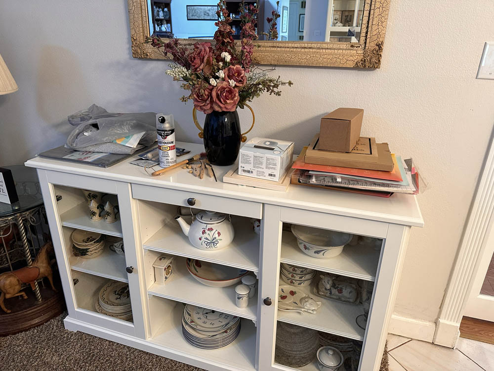 My crafting supplies sitting on top of our dining room hutch, 